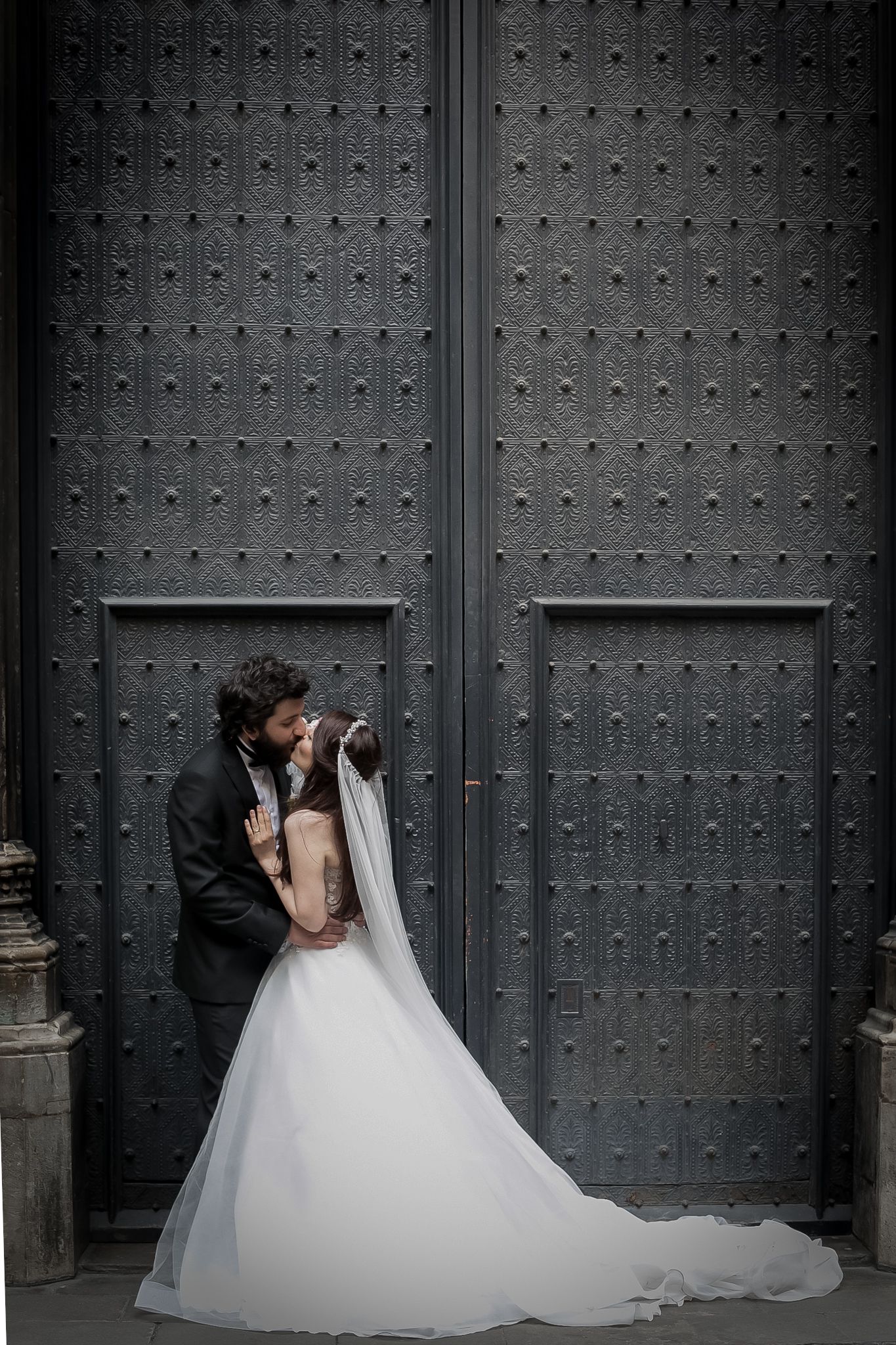 Bride and Groom kiss in front of tall doors