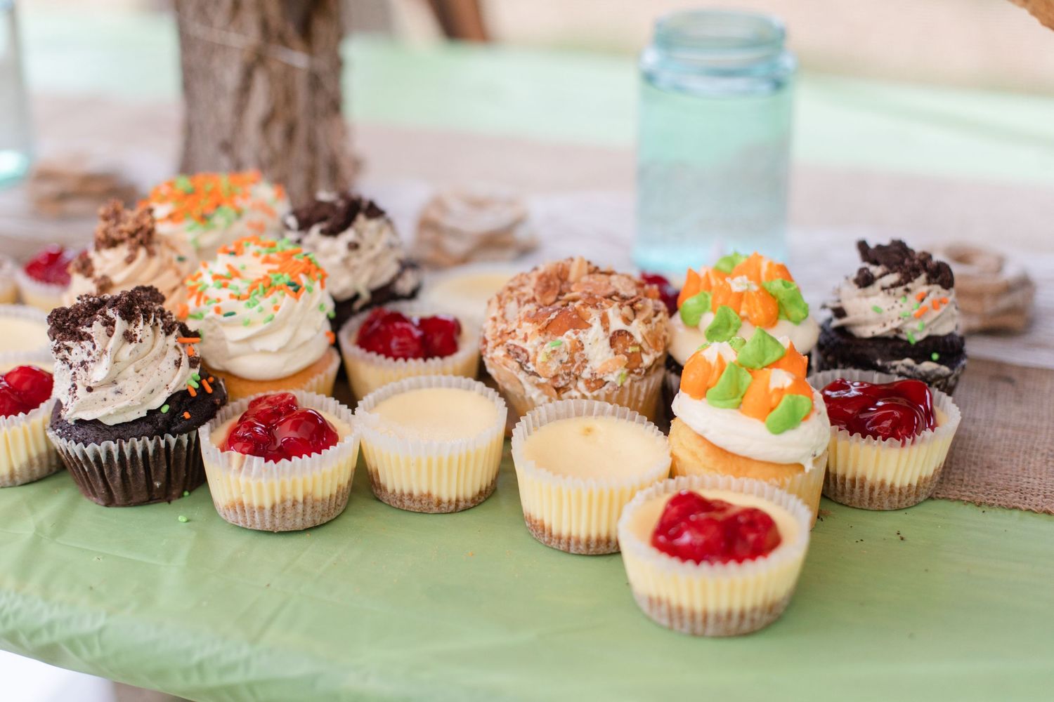 Assorted cupcakes with colorful frosting displayed on rustic wooden stands.