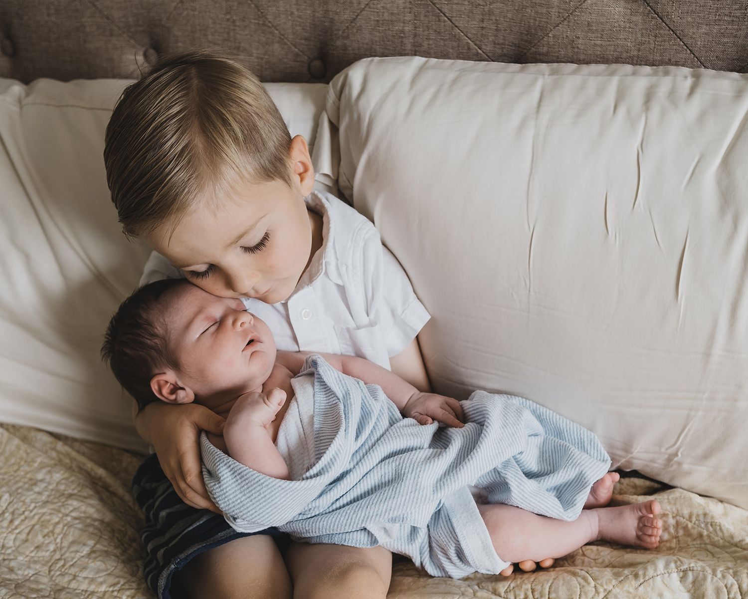 Salt Lake City newborn with his brother on the bed at home.