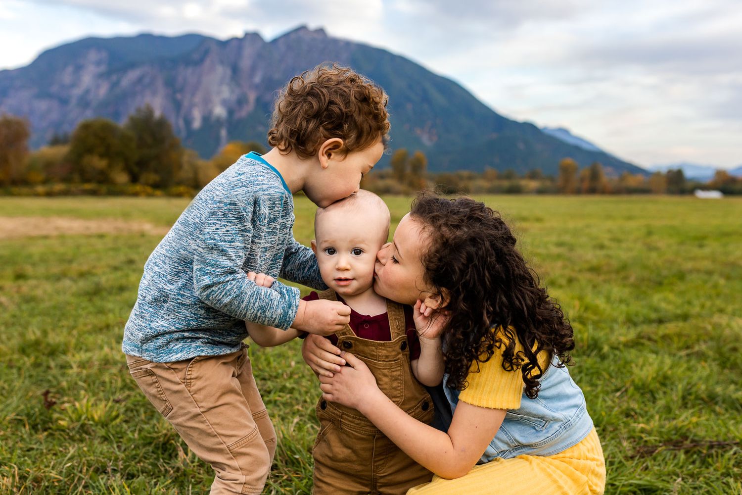 Siblings kissing each other tenderly in front of Mt. Si.