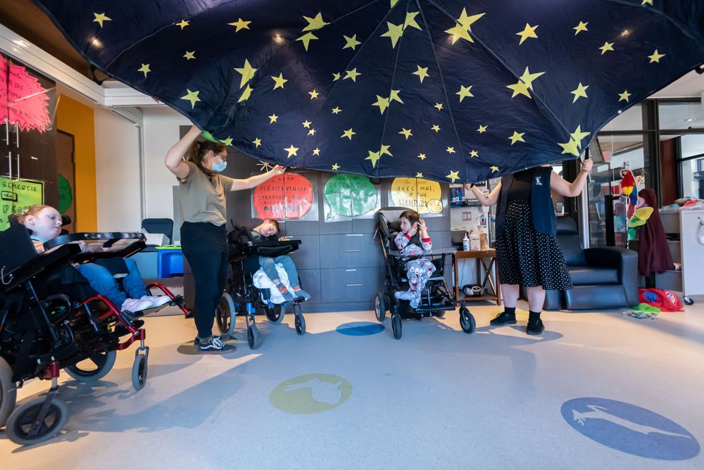 Children's playroom with yellow stars painted on dark blue ceiling and colorful floor designs.