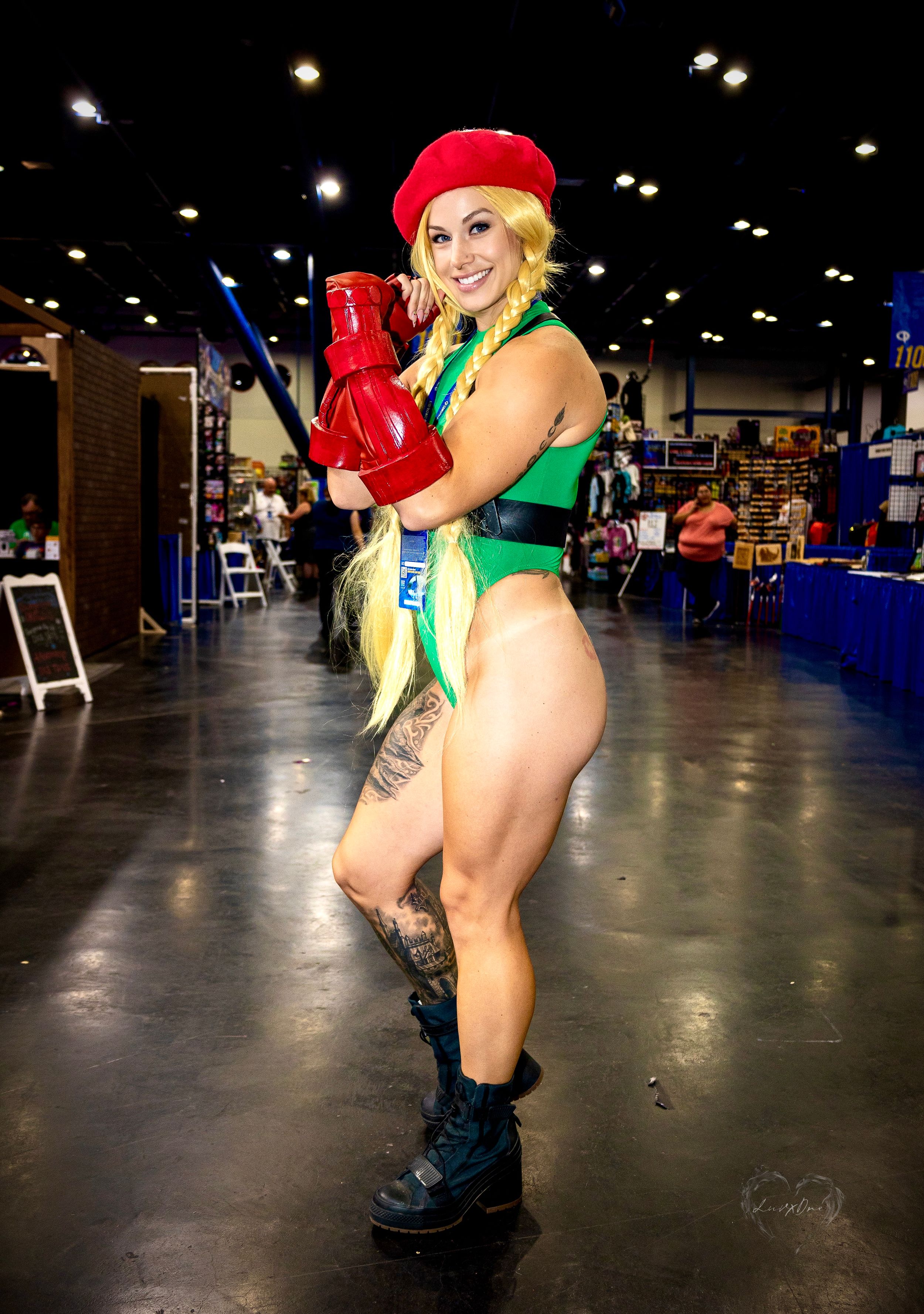 Cosplayer in Street Fighter Cammy-inspired costume poses at convention.