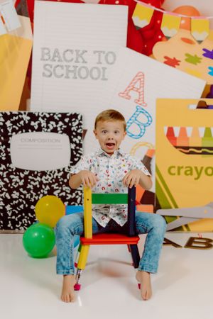Back to school themed photo with school supplies, balloons and composition notebook background.