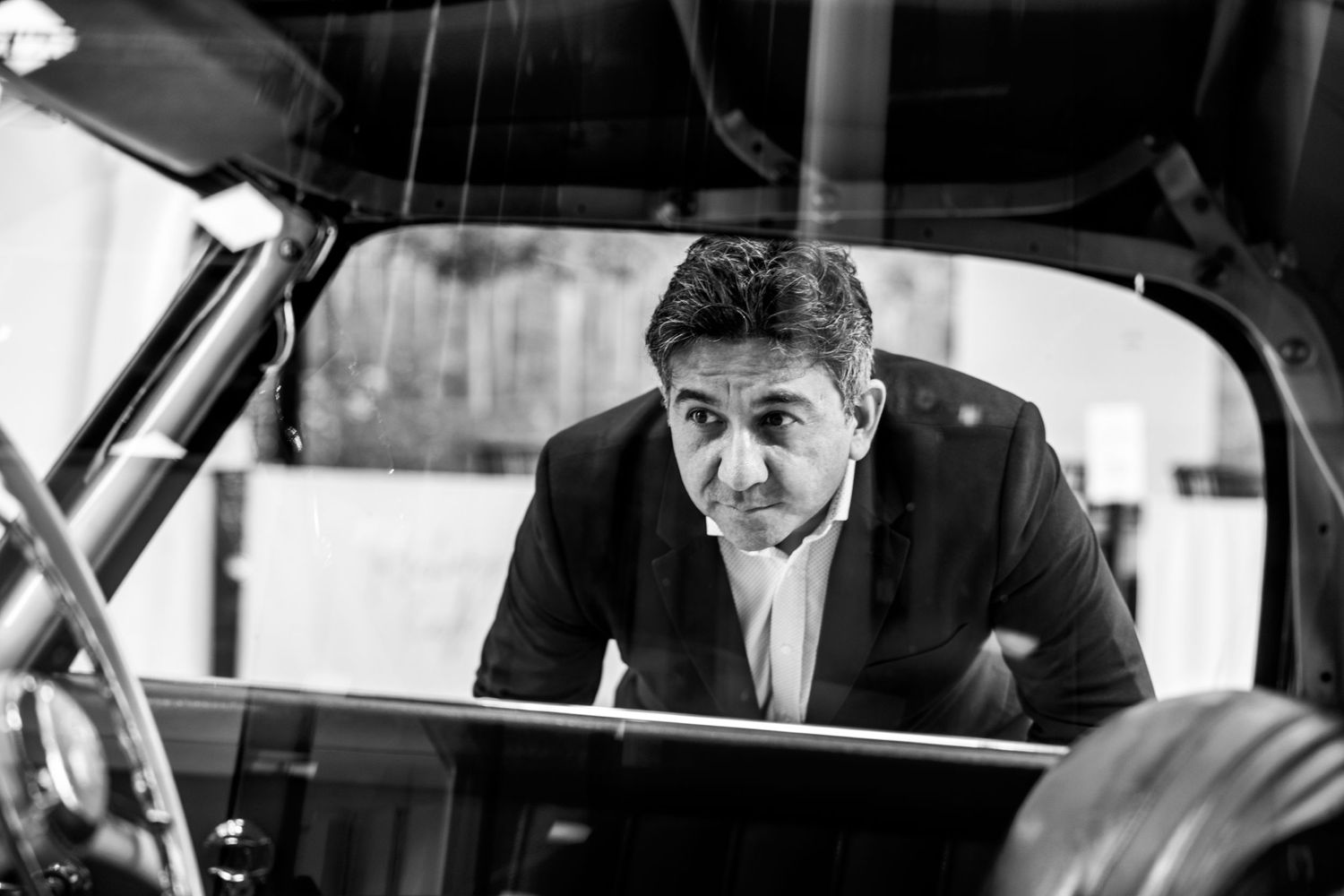 founder Indian man looking into vintage car window