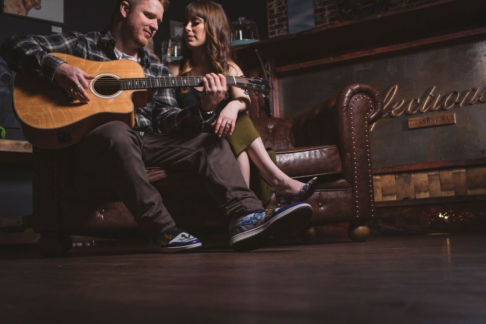 Cozy indoor scene with acoustic guitar and warm lighting creates intimate atmosphere.