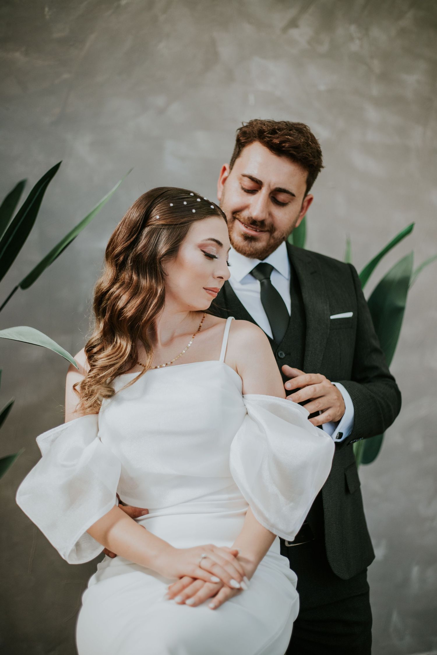 Bride and Groom looking at each other while Groom is holding the Bride sitting down