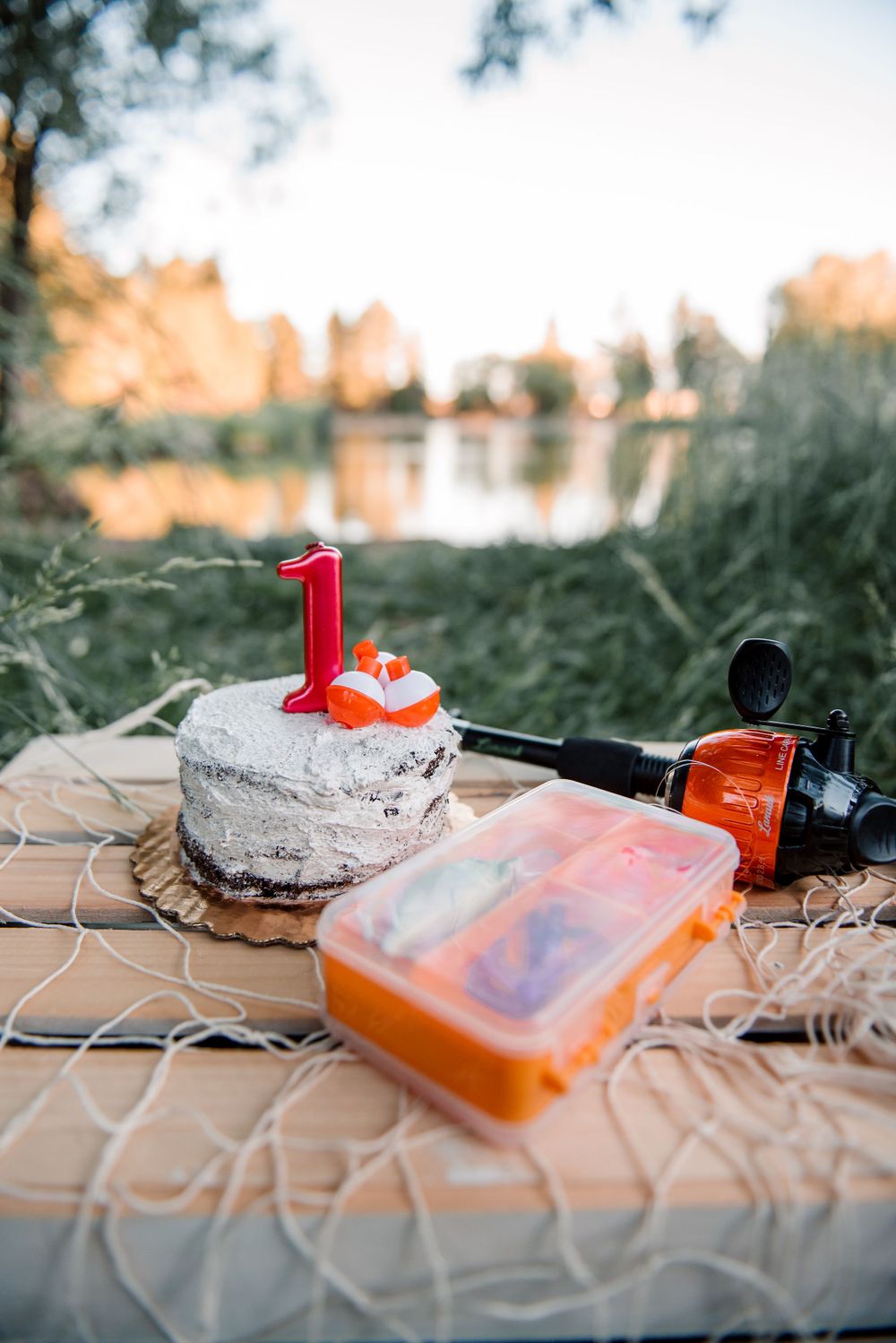 Orange and white fishing lure and equipment laid out on wooden surface.