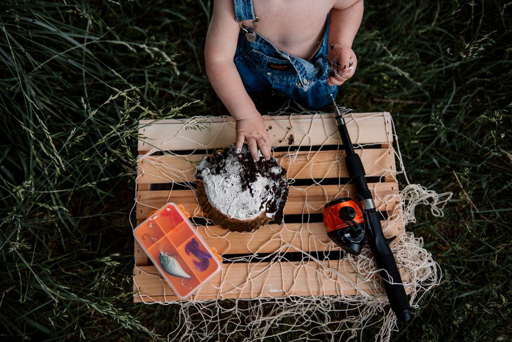 Wooden board with smashed cake and decorations during outdoor photo session.