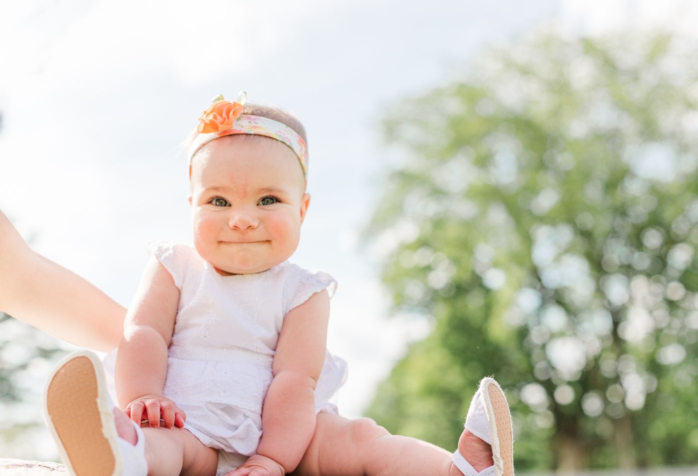 Baby portrait of a little girl in a white dress during a photo session with Danielle Lauren Photography