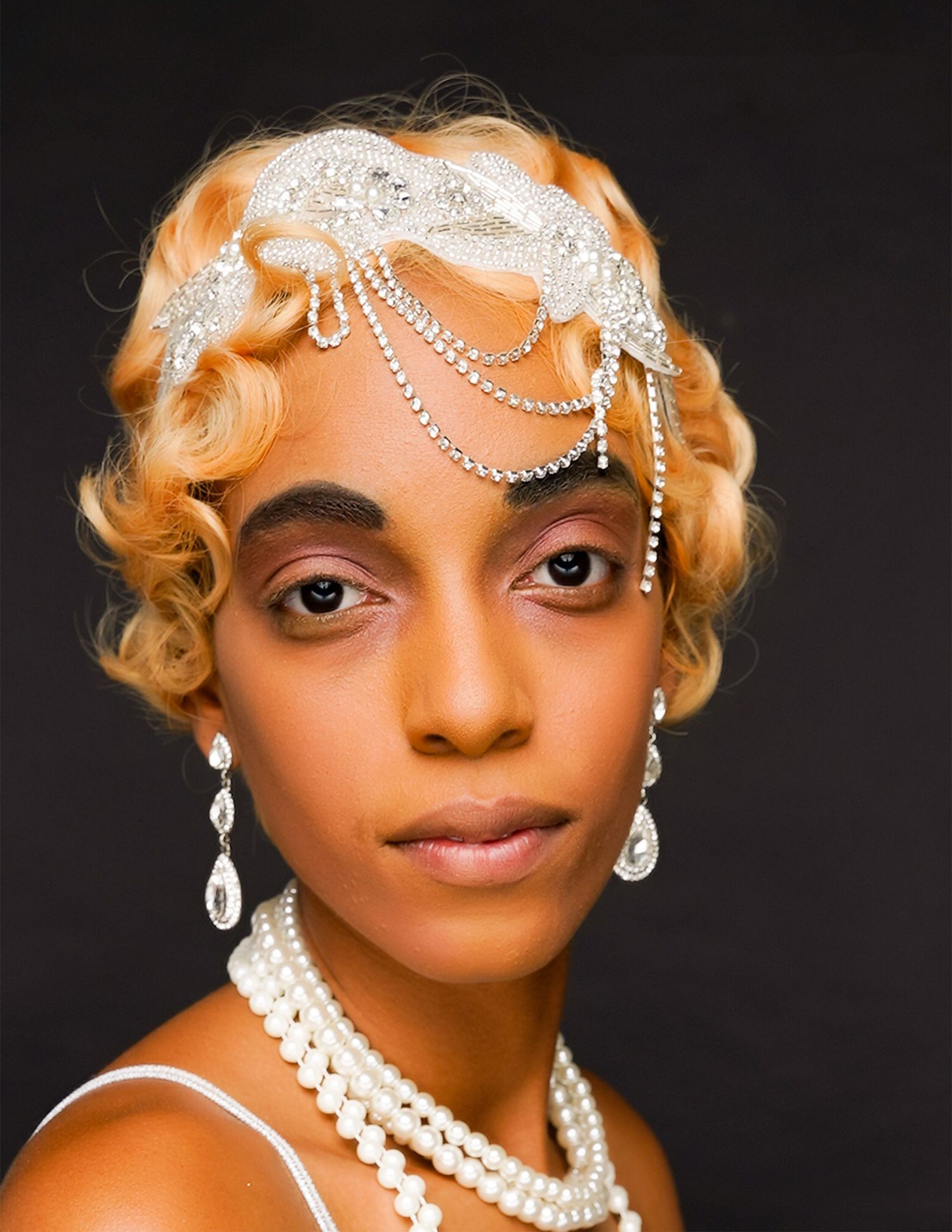 Vintage-inspired portrait with pearl headpiece and 1920s-style blonde waves.