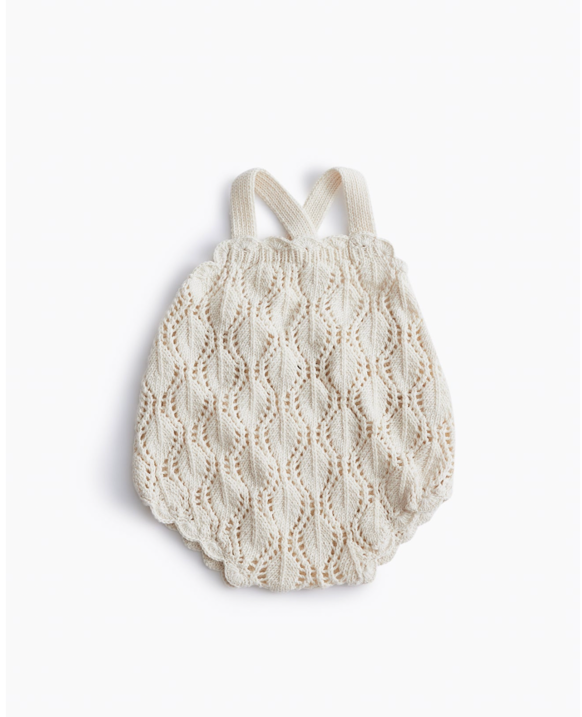Cream colored knitted baby romper with delicate scalloped pattern and straps.