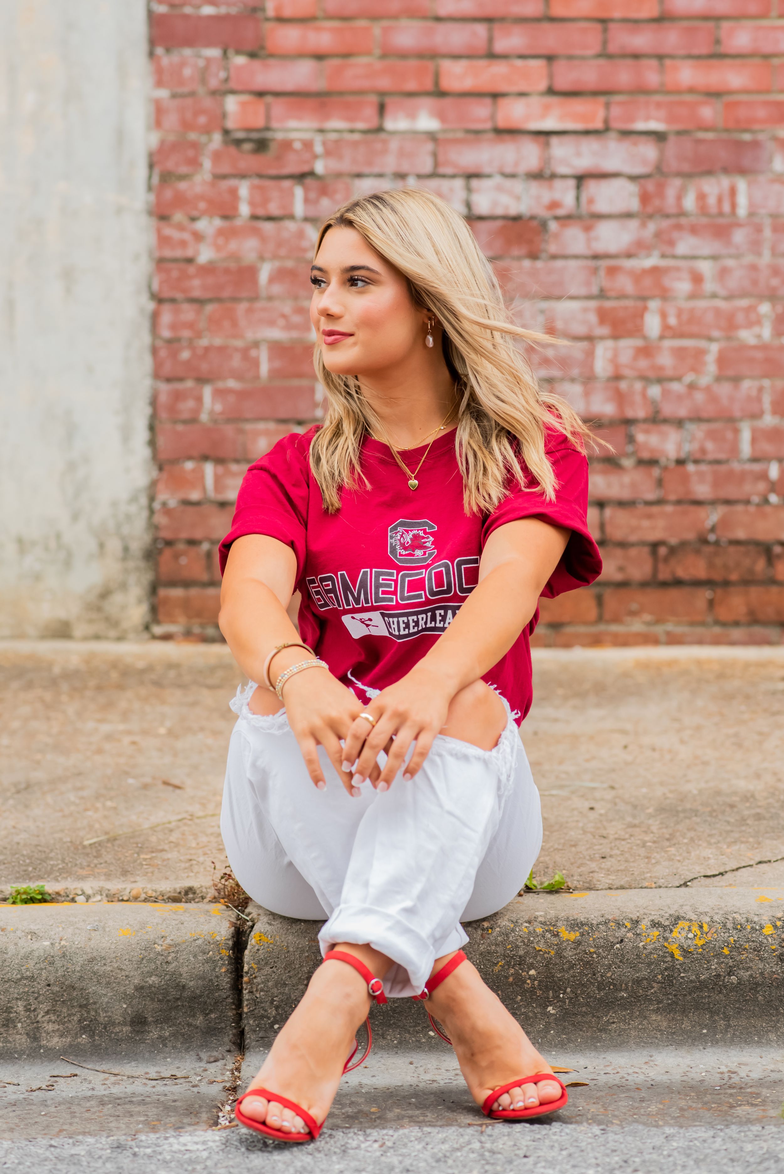 girls posing in front of brick during senior portrait session downtown Panama City Florida
