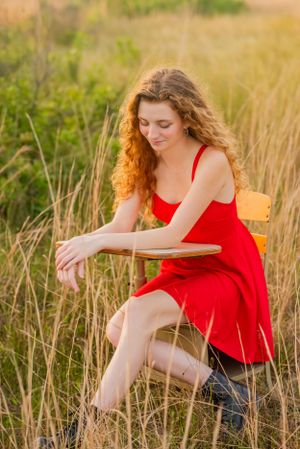 senior looking off in tall grass during fun candid senior portrait photoshoot in Panama City Beach Florida