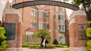 graduate with beautiful flowers during fun candid senior portrait photoshoot Panama City Florida