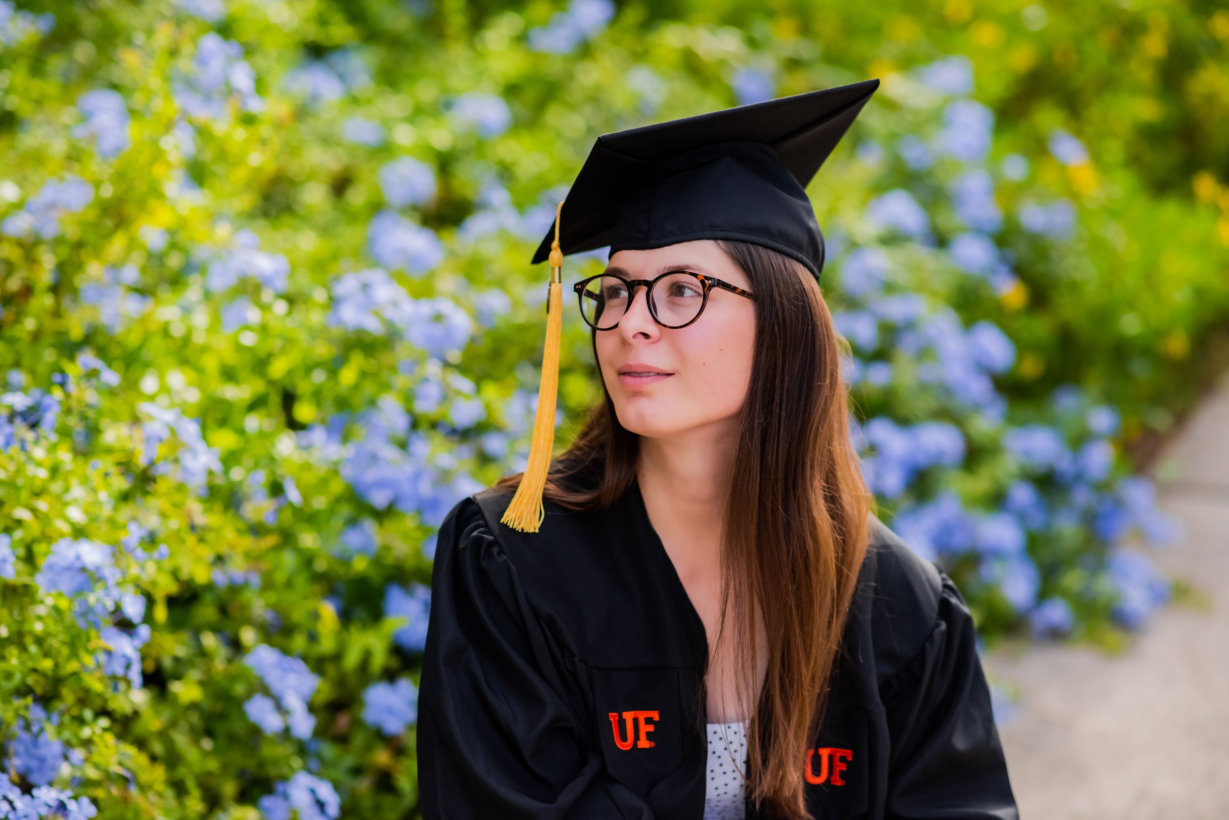 graduate with beautiful flowers during fun candid senior portrait photoshoot Panama City Florida