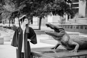 graduate with beautiful flowers during fun candid senior portrait photoshoot Panama City Florida