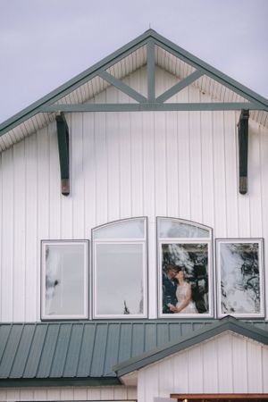 White building exterior with three windows and architectural details.