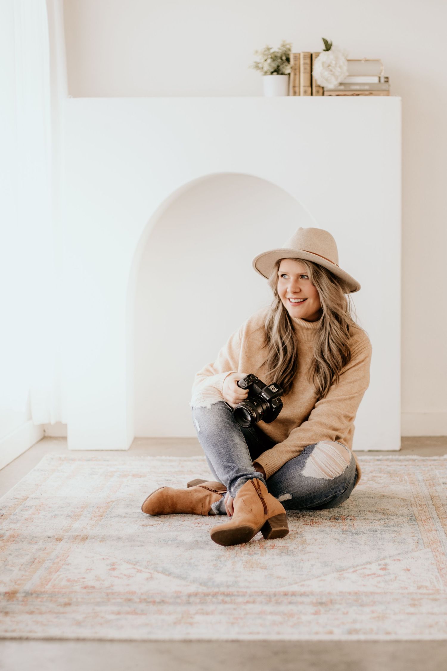 A Denver and Northern Colorado photographer holds her camera during an in-home newborn photo session in Denver