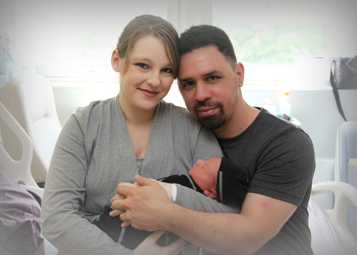 A tender moment captured in a hospital room with a newborn baby.