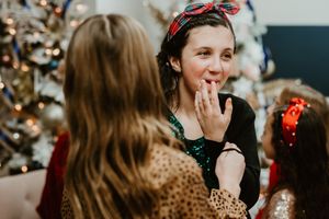 Two people having animated conversation with Christmas tree in background.