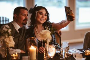 Guest takes a selfie while dining at an elegant candlelit reception.