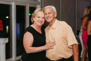 A couple embracing and smiling at a social gathering.
