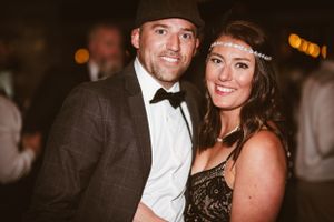 Couple in formal attire smiling at a fancy evening event.