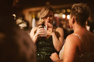 People celebrating at a dimly lit party with drinks and laughter.