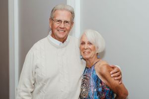 A senior couple smiling together at a social gathering.