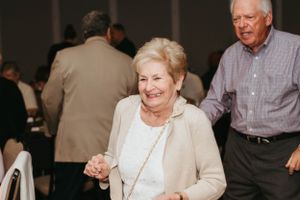 People enjoying a social gathering with dancing and celebrations in an indoor venue.