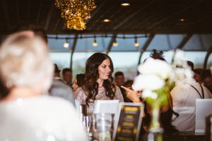 An elegant guest at a formal dinner reception listens intently to table conversation.