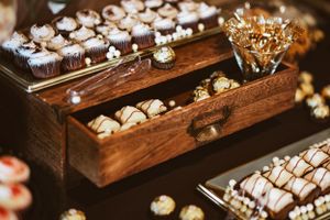 Wooden display boxes filled with assorted desserts and treats.