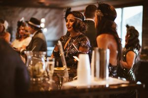 Partygoers enjoying themselves at a glamorous 1920s themed celebration.