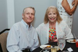 A couple smiles while dining at an indoor event.