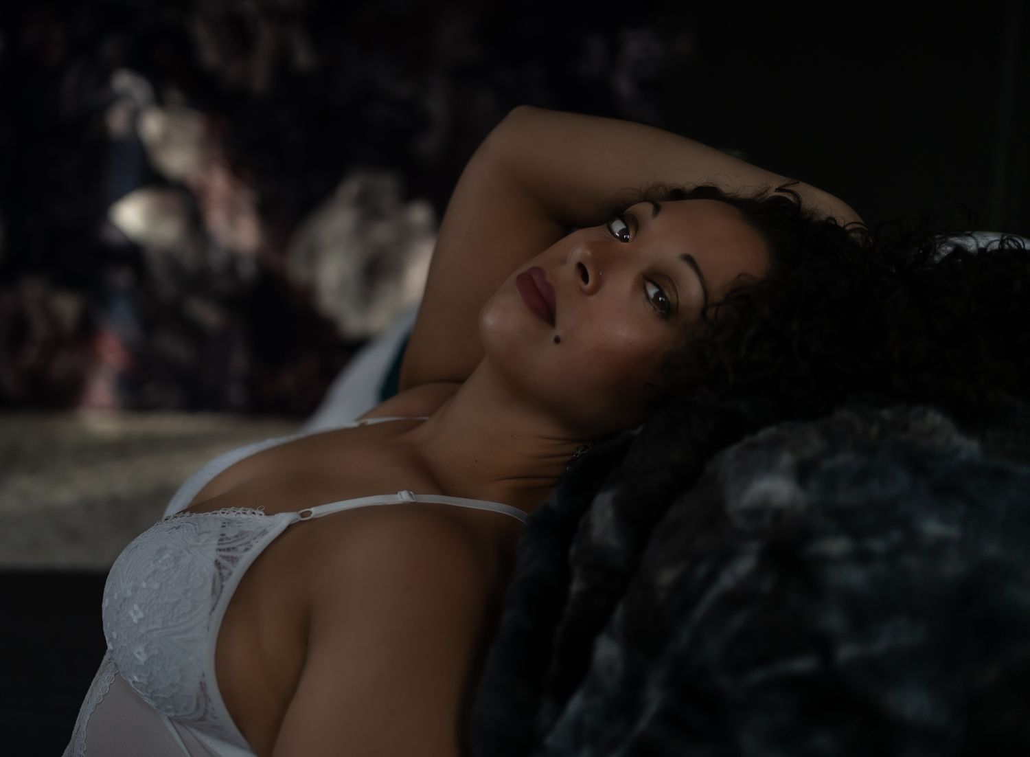 Intimate black and white boudoir portrait with soft lighting and delicate lace details.