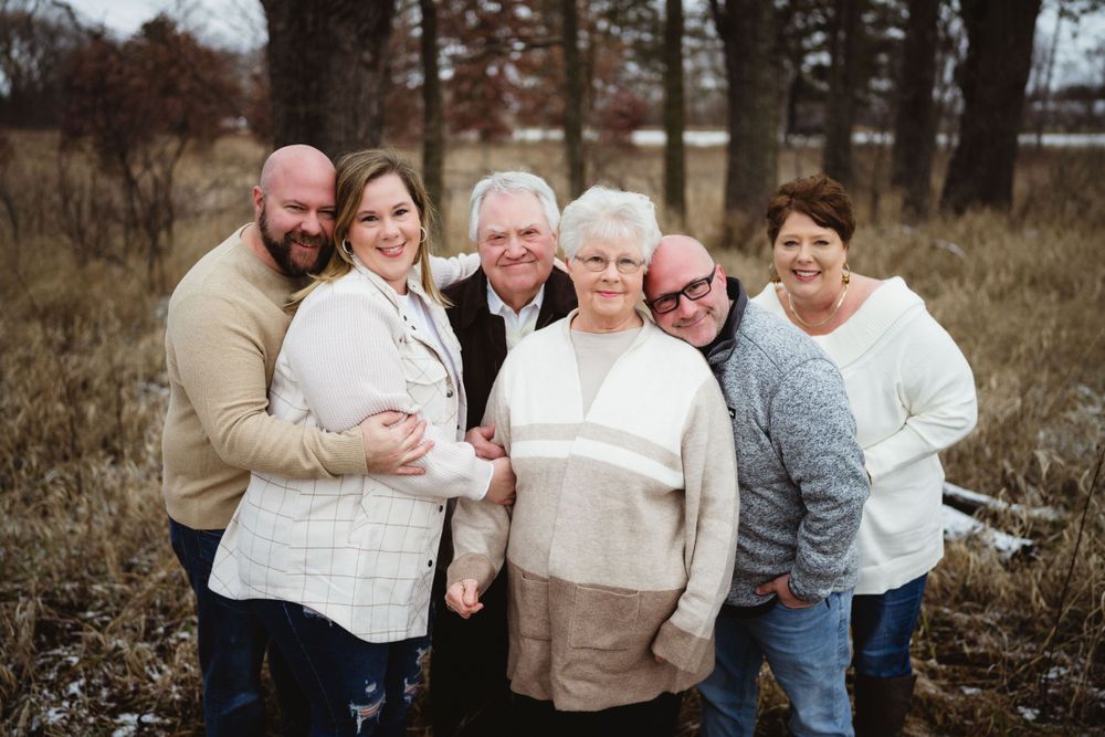 Candid group portrait of loved ones embracing outdoors in casual winter attire.