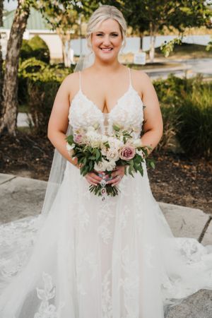 Elegant bridal portrait featuring a lace wedding gown and soft pastel bouquet.
