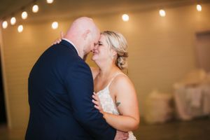 Couple embracing during intimate dance moment at indoor wedding reception.