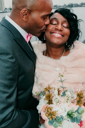 Romantic wedding moment captured with stunning bouquet of white and gold flowers.