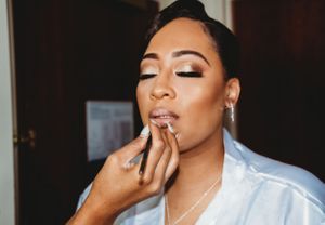 Getting ready shot showing elegant bridal makeup with white silk robe.