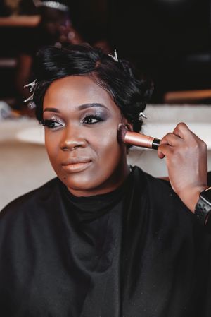 A makeup artist applies cosmetics during a beauty preparation session.