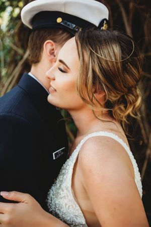 A tender moment captured between newlyweds with one in military dress uniform.