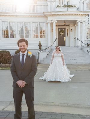 Wedding first look setup with couple separated outside elegant white colonial building.