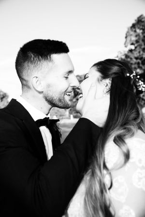 An intimate black and white portrait of a couple sharing a joyful moment together.