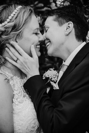 Intimate black and white portrait of newlyweds sharing a tender laughing moment.