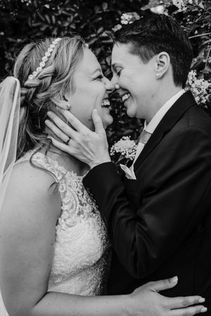 Black and white wedding photo showing joyful intimate moment between newlyweds.