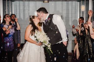 A joyful wedding reception scene with confetti falling as the couple shares their first dance.