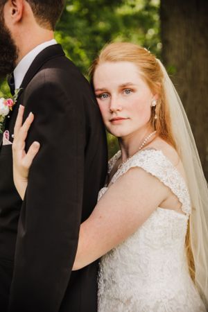 Elegant wedding portrait with bride in lace dress and veil.