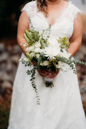 Close-up of a wedding bouquet featuring white flowers and cascading eucalyptus.