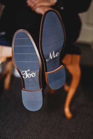 Creative wedding shoe photo showing 'I Do' and 'Me Too' written on blue soles.